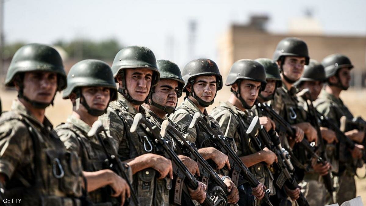 Turkish soldiers stand guar near the Turkey-Syrian border post in Sanliurfa, on September 4, 2015, as they wait for the arrival of the hearse carrying the body of three-year old Aylan Kurdi , whose lifeless body washed ashore on a Turkish beach. Images of the toddler Aylan whose lifeless body washed ashore on a Turkish beach spread like wildfire through social media and his plight has dominated international headlines, in a heart-rending symbol of the mortal risks faced by tens of thousands of refugees desperate to reach Europe by sea. AFP PHOTO / OZAN KOSE (Photo credit should read OZAN KOSE/AFP/Getty Images)